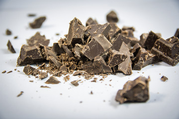 Pieces of dark chocolate bar on neutral background in studio shot