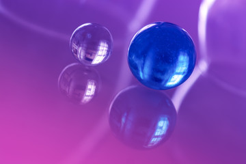 Two beautiful glass ball on a glass table with reflection.
