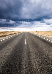 Naklejka premium Under the clouds, the road to the distance.