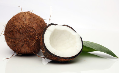 Coconut with half and leaves on white background.