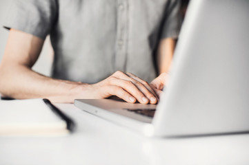 Business man using laptop computer. Male hand typing on laptop keyboard
