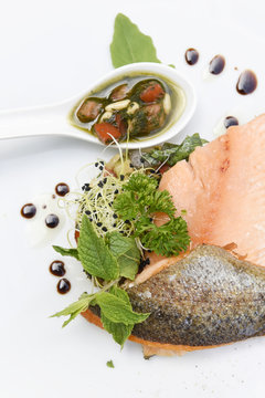 Plate of salmon fillets with fresh herbs, vegetables and balsamic vinegar  