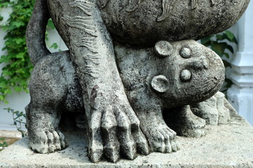 Ancient Lion Cub Statue in Front of Temple Entrance.