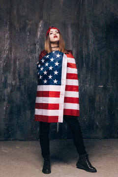 Proud girl dressed in USA flag on dark background. American patriot, national event celebration, pride, usa citizen concept