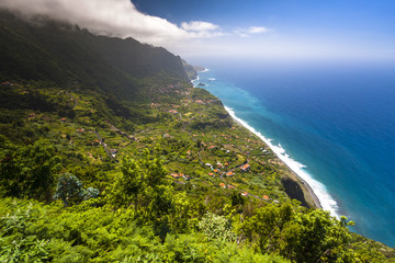 Fototapeta na wymiar Green Madeira coast with azure water and blue sky