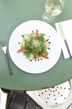 Green salad, parsley, tomatoes and fresh onions on a bed of quinoa served on the terrace