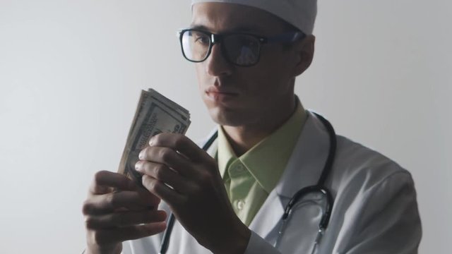 Doctor counts the money. A bribe to a medical worker. Expensive medicine.