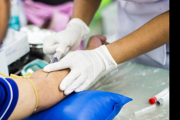 Fototapeta na wymiar Physical examination - Nurse doing Blood sampling with syringe and needle for analysis