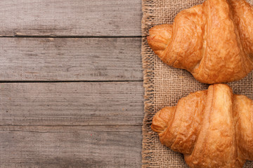two croissants on old wooden background with copy space for your text. Top view
