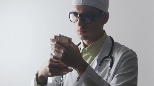 Doctor counts the money. A bribe to a medical worker. Expensive medicine.