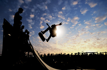  Jumping skateboarder silhouette over scenic sunset sky background