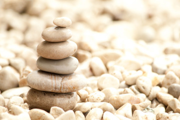 Close up image of six pebbles stacked into a zen pagoda on a shingle beach

