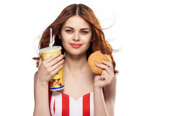 Woman hungry, woman with a hamburger and a glass on an isolated background