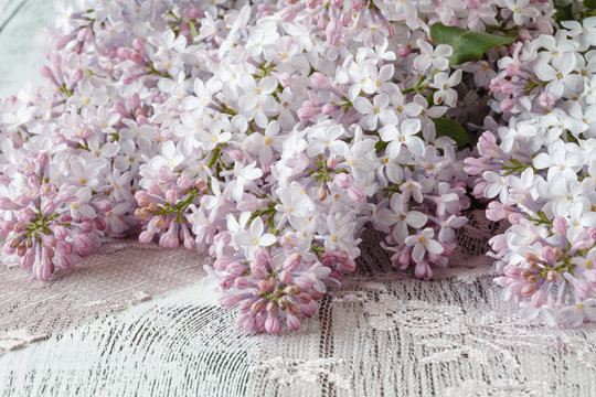 Background with fresh lilac flowers on turquoise painted wooden planks.