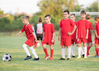 Kids soccer football - children players exercising before match on soccer field