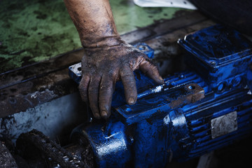 hand of repairman during maintenance work of electric motor