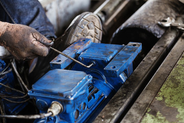 Hand holding hexagonal wrench and during maintenance work of electric motor