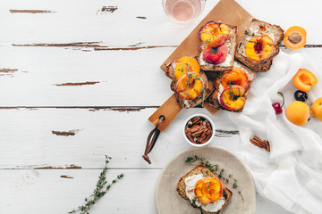 Summer snack: sandwiches with grilled peaches, cream cheese, thyme and pecan with a glass of...