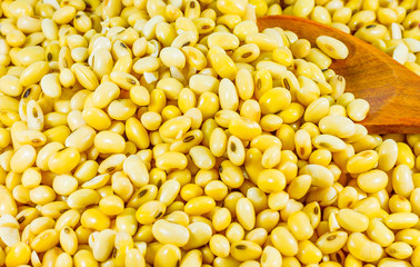 Soy bean in wood spoon full on wooden background,Macro shot of soybeans fills the frame, selective focus,texture,soy milk,soy oil
