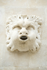 Close-up of the expressive face carved in stone with a mouth as a spigot for a fountain in Dubrovnik, Croatia