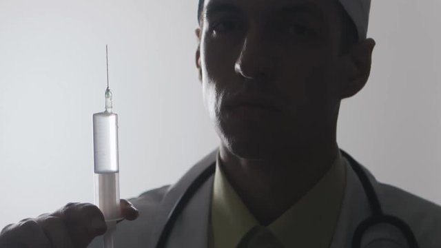 Portrait of a doctor with a syringe. An injection