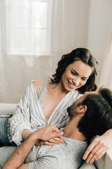 Happy young couple hugging and smiling each other at home