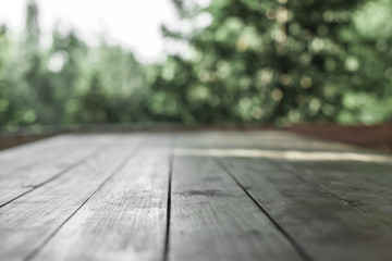 Wooden board  in front of blurred nature background. 