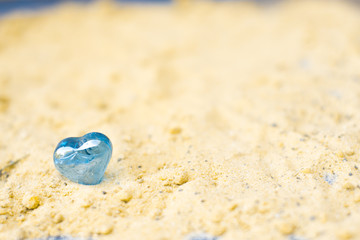 Heart on a sandy sunny beach happiness concept.