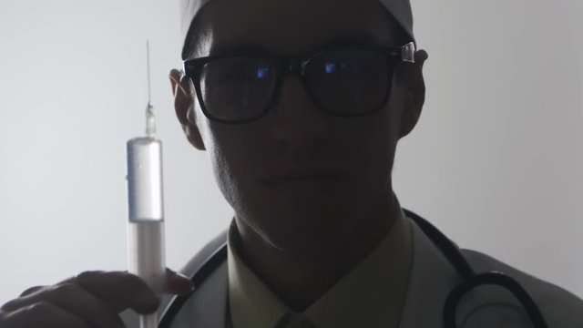 Portrait of a doctor with a syringe. An injection