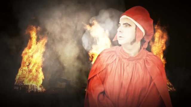 A man in Hell with burning fire and smoke clouds: Dante Alighieri, the 13th century Italian Poet (a dressed up actor). He starts speaking and he looks serious.
