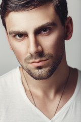 Obraz premium Fashionable male studio portrait. Caucasian white bug with bristles. A large portrait of a guy in a white T-shirt.
