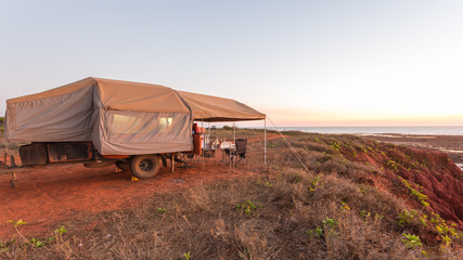 Off Road Camper Trailer set up on top of cliffs with stunning ocean views at James Price Point, Kimberley, Australia.