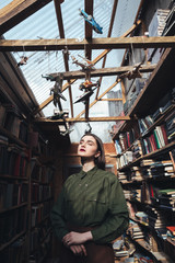 Young girl standing against sun in library