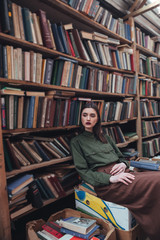 Confident woman sitting on books