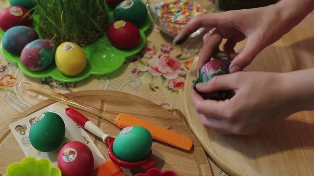 The girl arranges decorated easter eggs