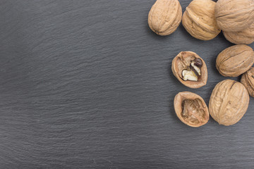 Red rice and olive wood scoop on black background of slate or stone. 