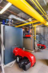 The interior of a modern gas boiler house with boilers, pumps, valves and a multitude of sensors