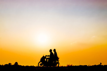 Young man and his girl friend travel by motorcycle at sunset, Abstract Silhouette image.
