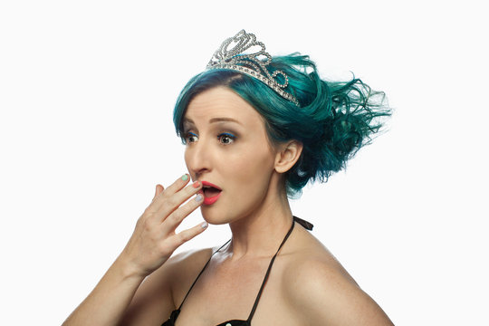 Young woman with green hair wearing tiara and looking surprised