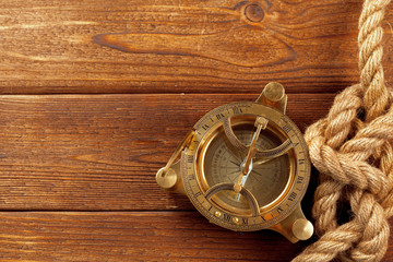 Compass and rope on wooden table. close up