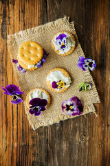 Sandwich with herb and edible flowers butter on wooden background, healthy food.