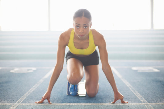 Young female athlete on starting blocks