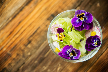 Obraz na płótnie Canvas Fresh green salad with herbs and garden flowers. Healthy food concept