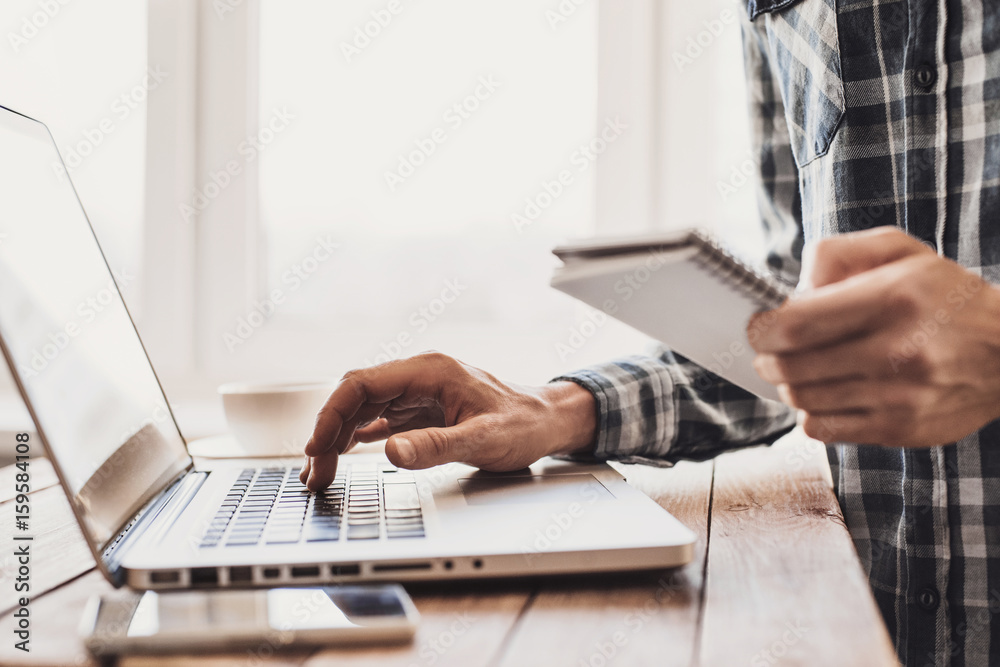 Wall mural Business man using laptop computer. Male hand typing on laptop keyboard