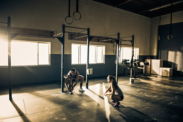 Female trainer talking to male client in gymnasium