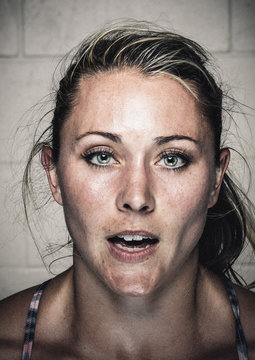 Portrait of sweaty young woman with open mouth after workout
