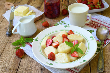 Summer berry breakfast. Sweet lazy pierogi, dumplings with sour cream, butter and strawberry on...