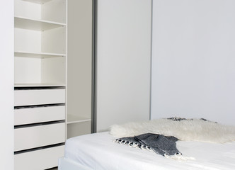 Fototapeta na wymiar Modern home interior.Built-in wardrobe with sliding doors in the light interior of the bedroom. Small room. One of the doors of the built-in wardrobe is open. European furniture, design, technologies.