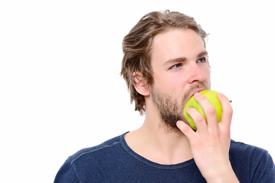 Man with sexy sight, thoughtful face expression biting green apple