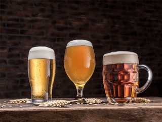 Different glasses of beer on the wooden table.